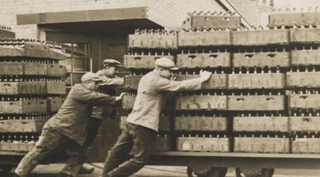 Fotografia antiga d'arxiu. Treballadors carregant caixes de cerveses a un camió